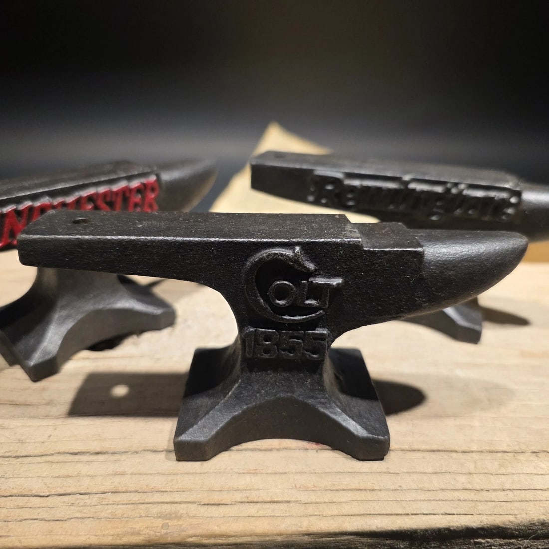 Cast Iron Miniature Anvil Advertising Collection Lot: (3) Anvils as shown each are roughly 4 3/4" long x 2 1/2" Tall x 1 3/4" Wide 1 lb. 5 oz. Set of three cast iron mini anvils featuring bullet-shaped tops, marked Colt, Winchester, and Remington. These 