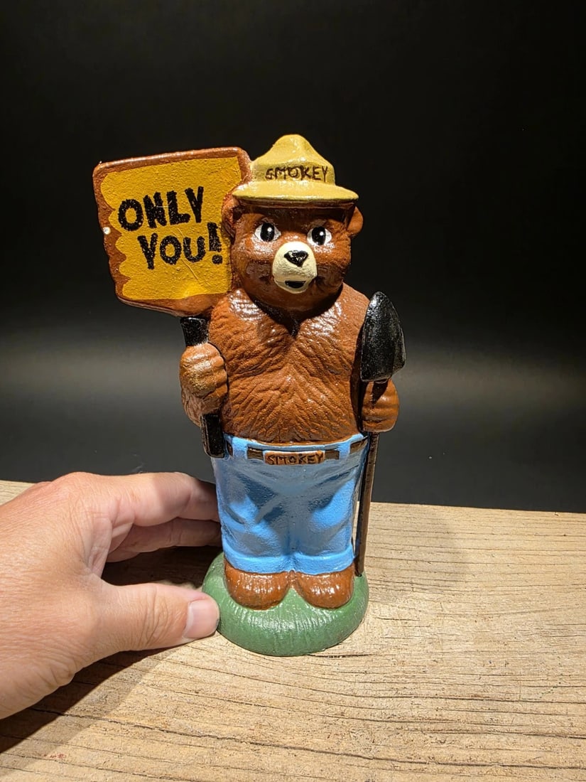 8" Cast Iron Smokey The Bear Coin Bank: 5 L x 3.5 W x 8 H Such a good reproduction cast iron bank depicting Smokey Bear, known for his role in wildfire prevention. This particular bank is designed in an antique vintage finish, hand-painted 