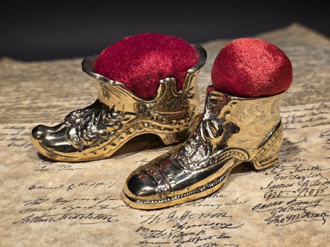 3" Miniature Brass Boot Sewing Pin Cushion Collection: (2) Vintage-style brass boot pincushion with a rich red velvet top. Cast in solid brass with crisp shoe detailing, these pieces echoe late 19th-century sewing accessories often found in tailor shops a