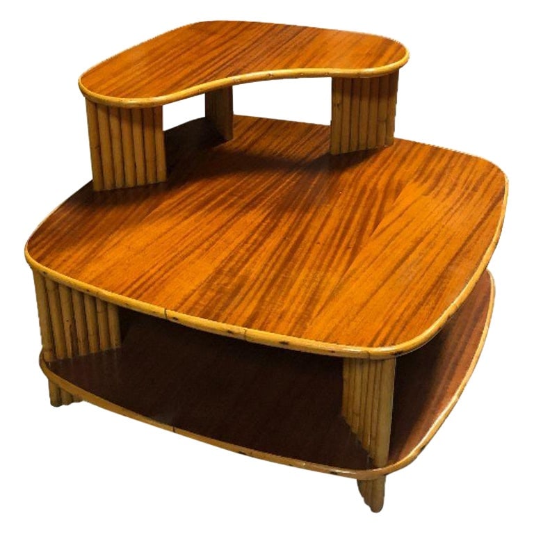 Restored Rattan 1940s Double Level Corner Table with Quatered Koa Wood Top: Title: Restored Rattan 1940s Double Level Corner Table with Quatered Koa Wood Top Description: This beautifully restored Paul Frankl-inspired rattan corner table with a striking dimensional quartered