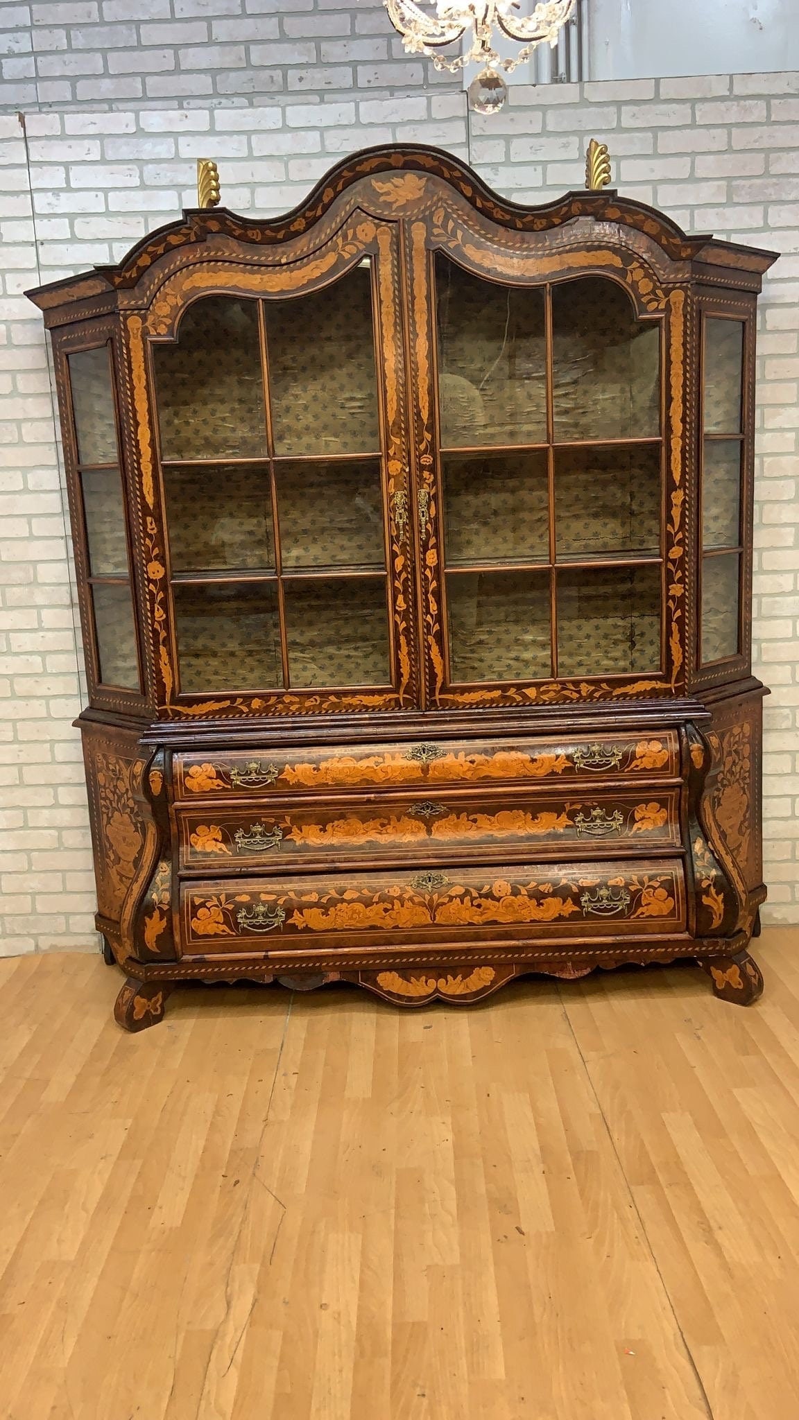 Antique Dutch Marquetry Vitrine Cabinet/Display Hutch: Materials: wood, glassAntique Dutch Marquetry Vitrine Cabinet / Display Hutch with DrawersThis beautifully crafted piece features intricate floral wood inlay throughout, a serpentine shaped crown,