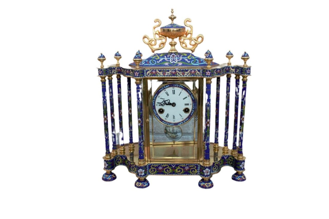 MCM Chinese Cloissoné Mantel Clock: Mid Century Chinese Cloisonné Mantel ClockDecorate your mantlepiece with this intricately designed cloisonné clock. The clock face is flanked by columns decorated with flowers. The piece is