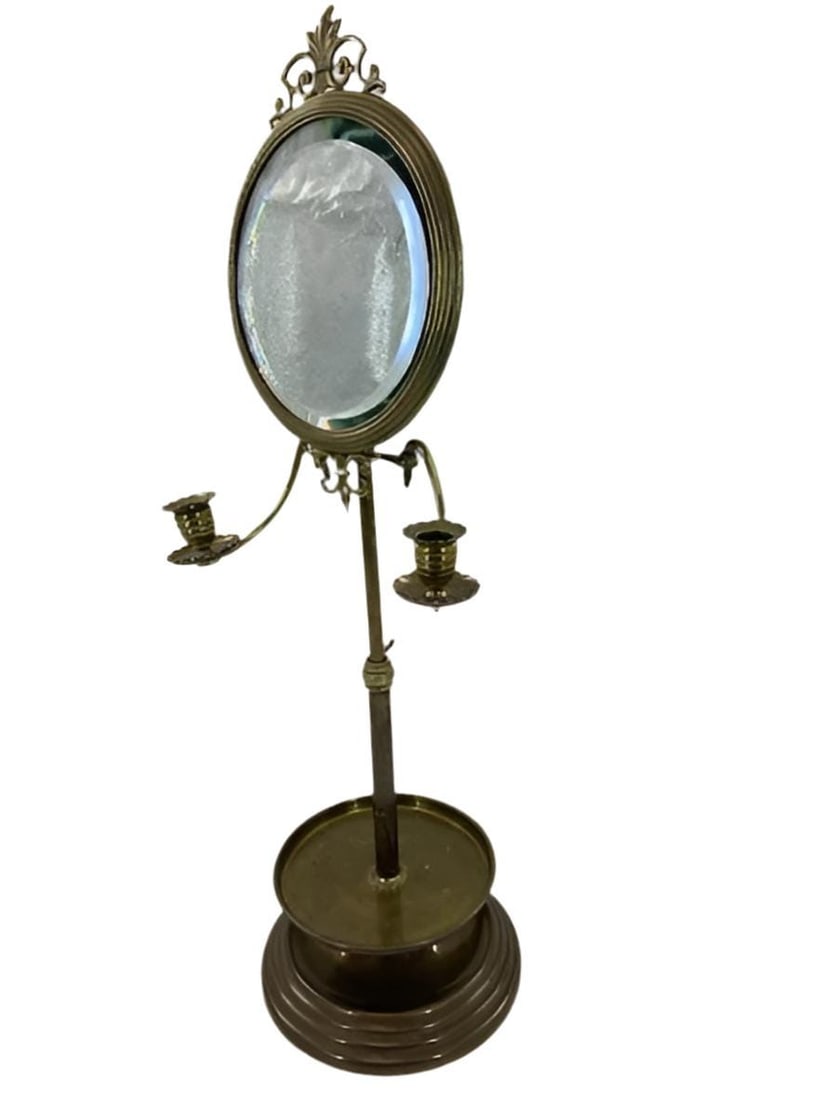 Antique Victorian Brass Shaving Stand Mirror with Candle Holders: Materials: BRONZE, GLASS, METAL, MIRRORAntique Victorian Brass Shaving Stand Mirror with Candle HoldersAntique Victorian brass shaving stand featuring an oval mirror with ornate crest, dual candle hol