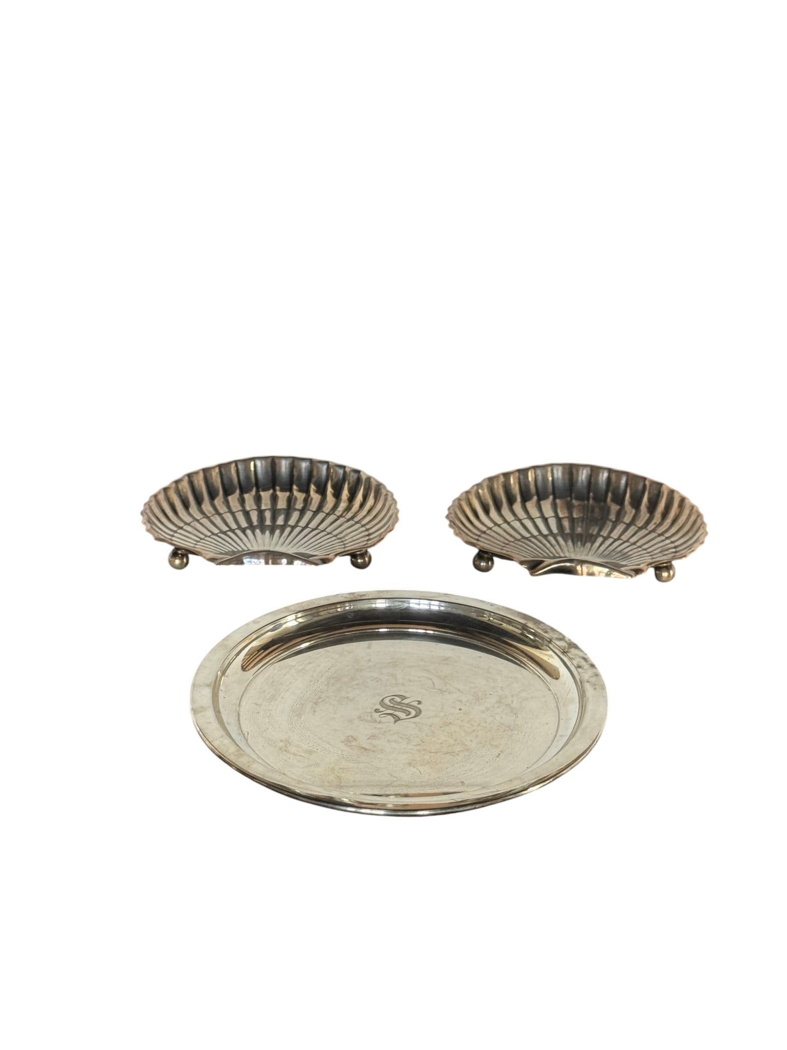 Three-Piece Sterling Silver Gorham Shell Dishes and Martini Tray Set: A charming three-piece set of sterling silver tableware, comprising two scallop-shell shaped dishes and one circular martini tray. Each shell dish rests on three spherical feet and features a ribbed i