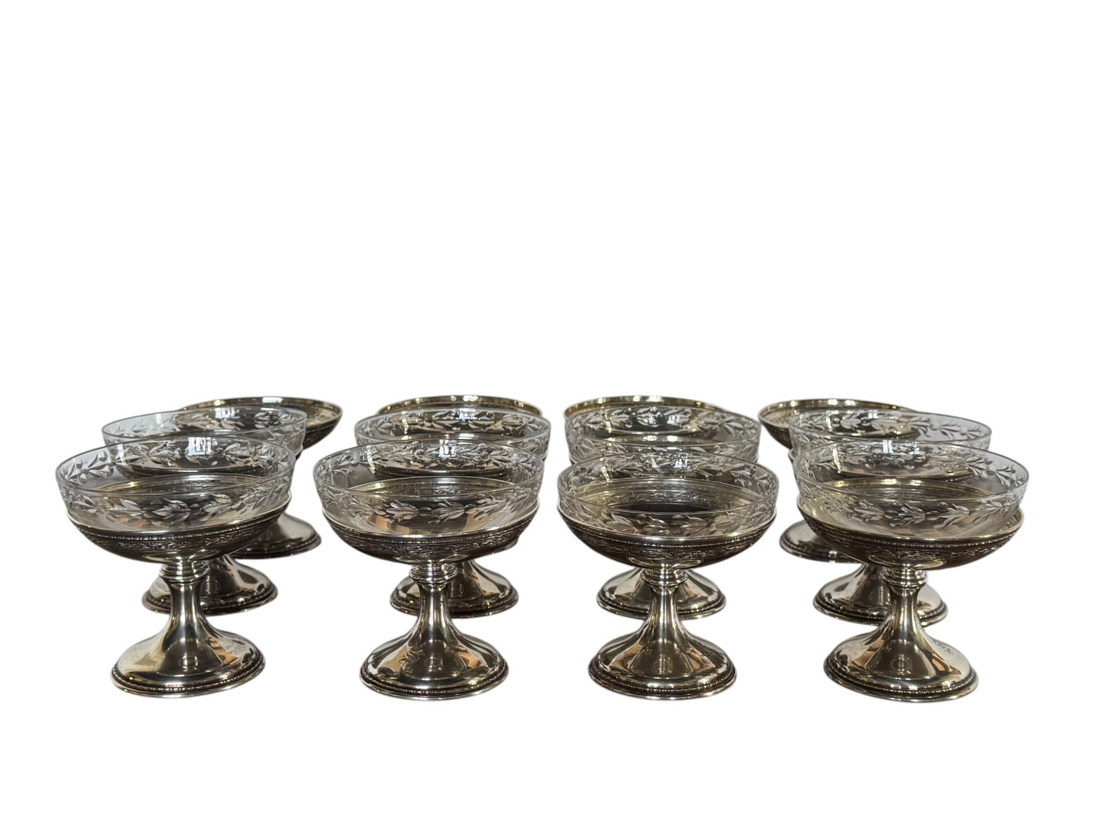 Set of Twelve Gorham Sterling Silver and Etched Glass Sherbet Cups: This elegant set comprises twelve sherbet cups, each featuring a sterling silver base and an etched glass bowl. The sterling silver bases, crafted by the renowned Gorham Manufacturing Company, are