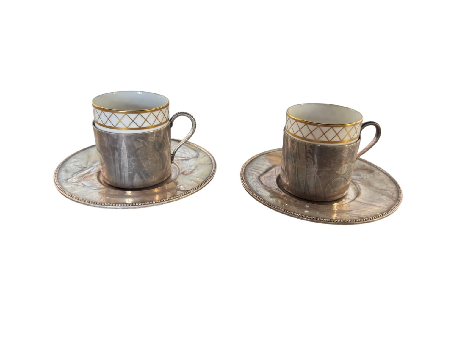Pair of Tiffany & Co. Sterling Silver Demitasse Cup Holders with Spode Bone China Cups: A distinguished pair of Tiffany & Co. sterling silver demitasse cup holders, accompanied by two Spode bone china cups. The sterling silver holders feature intricately crafted handles and a simple, ele