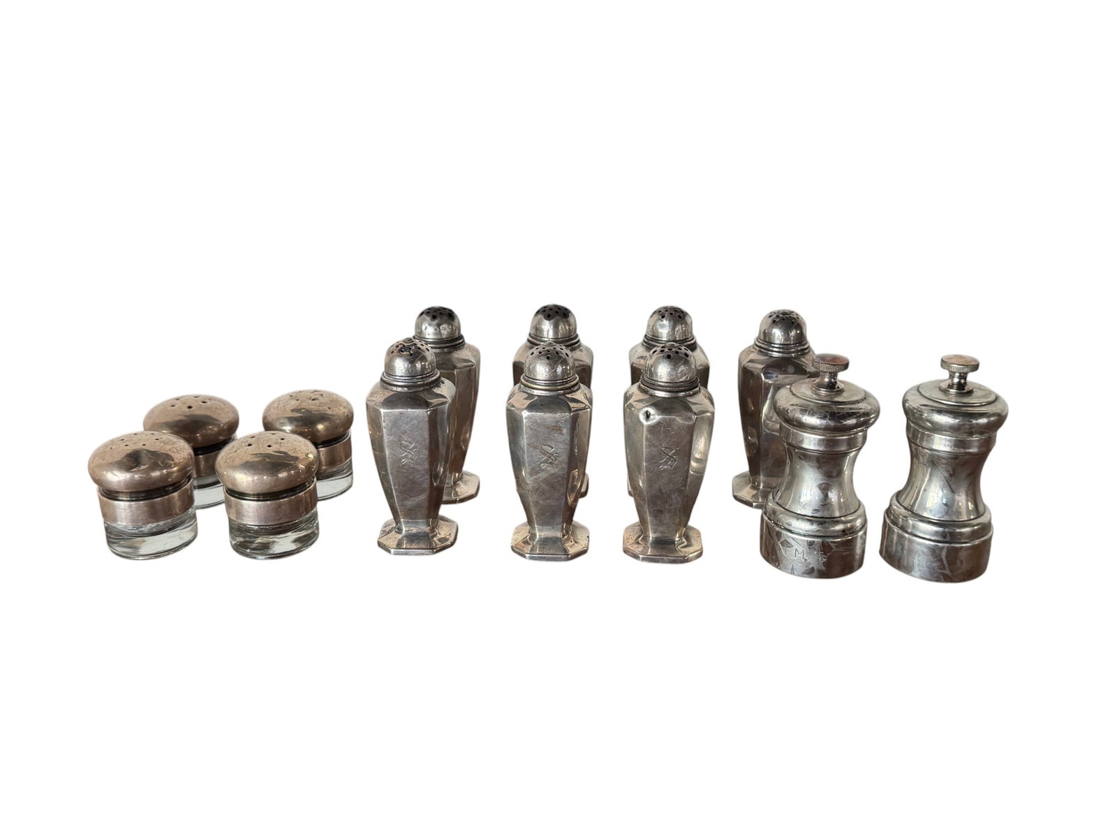 Collection of Sterling Silver and Glass Salt and Pepper Shakers: This lot presents an extensive collection of salt and pepper shakers, primarily featuring sterling silver construction or sterling silver tops paired with glass bodies. The collection includes