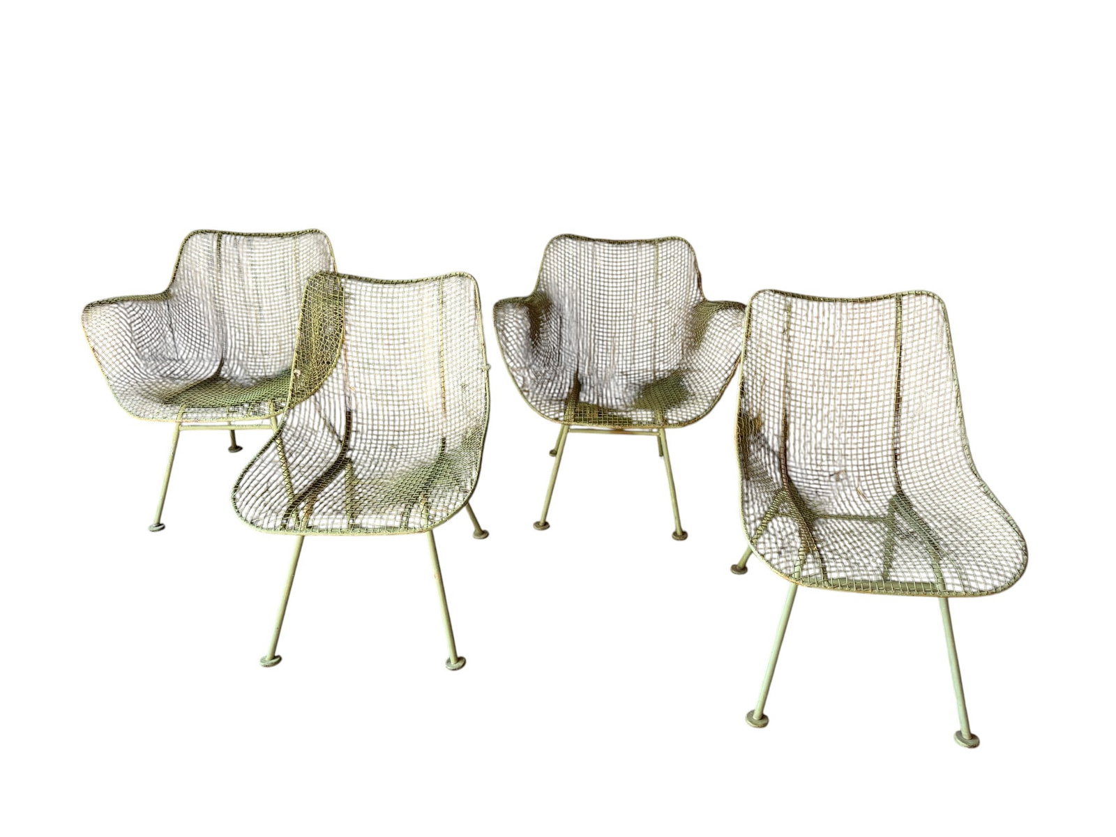 Set of Four Mid-Century Modern Iron Woodard Sculptura Mesh Patio Chairs: A set of four mid-20th century patio armchairs, likely produced in the 1950s or 60s. Each chair features a curved seat and back made from iron mesh, supported by a tubular iron frame with splayed legs