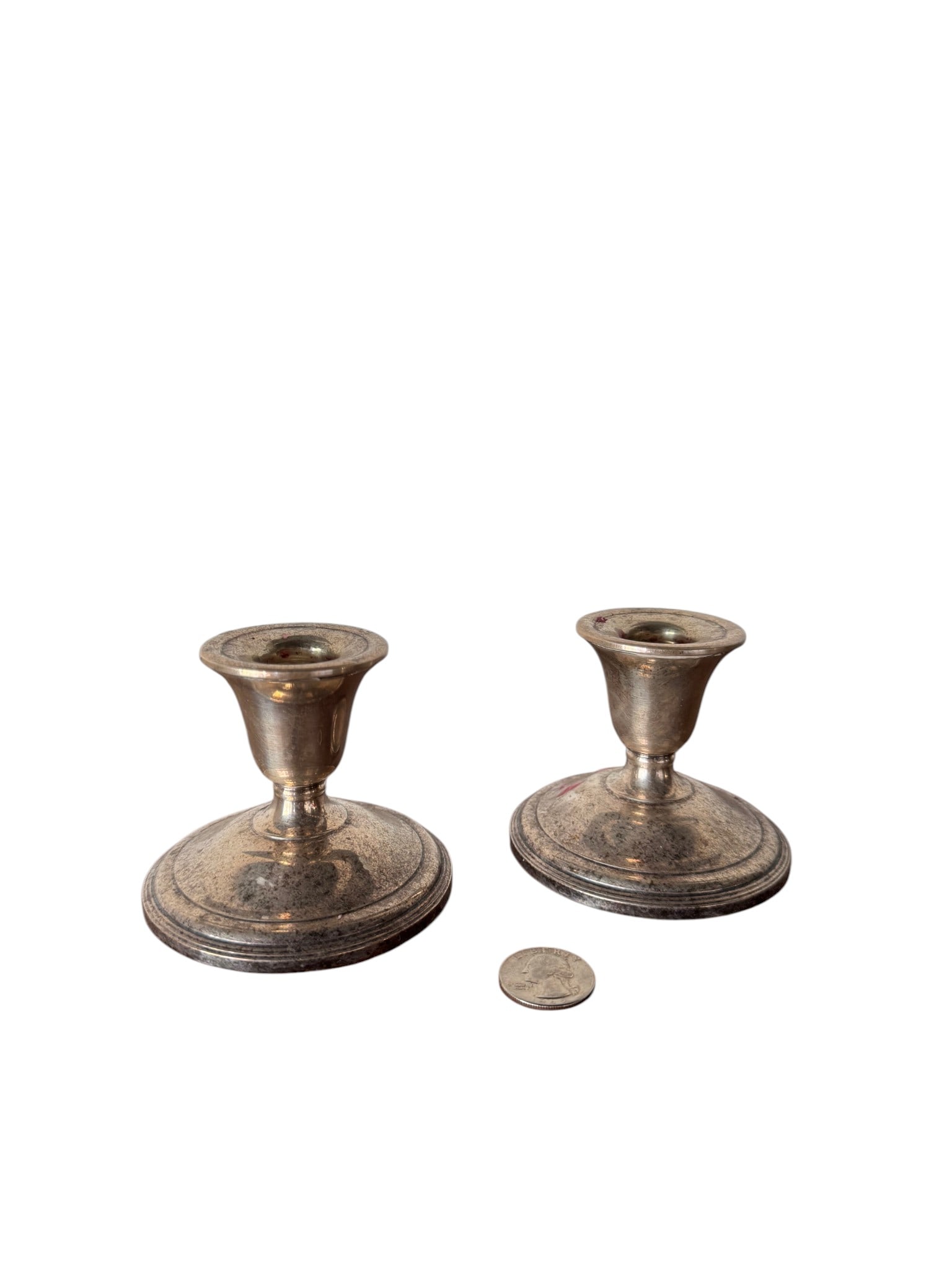 Pair of Sterling Silver Candlestick Holders: A classic pair of sterling silver candlestick holders, possibly early to mid-20th century. Each features a traditional design with a circular base and a simple, elegant stem leading to the candle