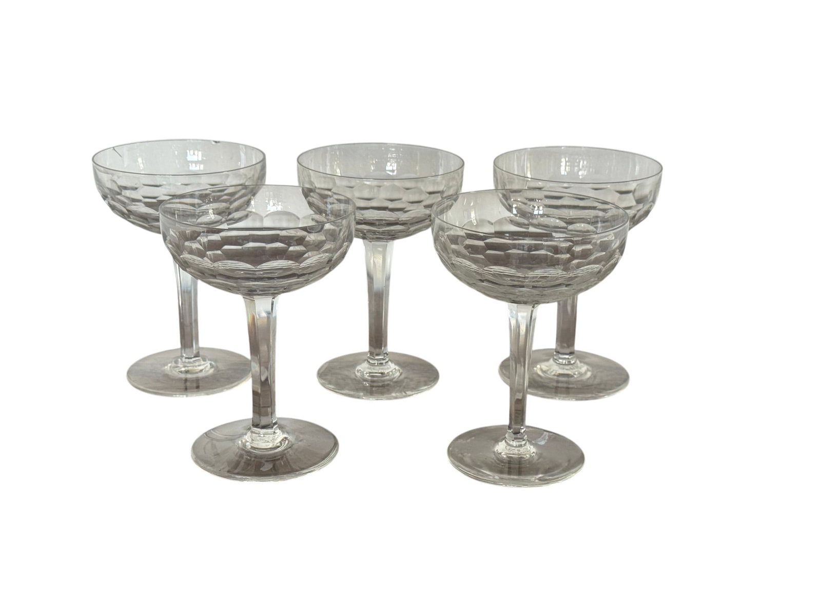 Set of Five Baccarat â€œHoneycombâ€ Pattern Crystal Coupe Glasses: An elegant set of five Baccarat crystal coupe glasses, featuring the distinctive "Honeycomb" pattern on the bowls. These glasses, likely dating from the mid-20th century, showcase the exquisite