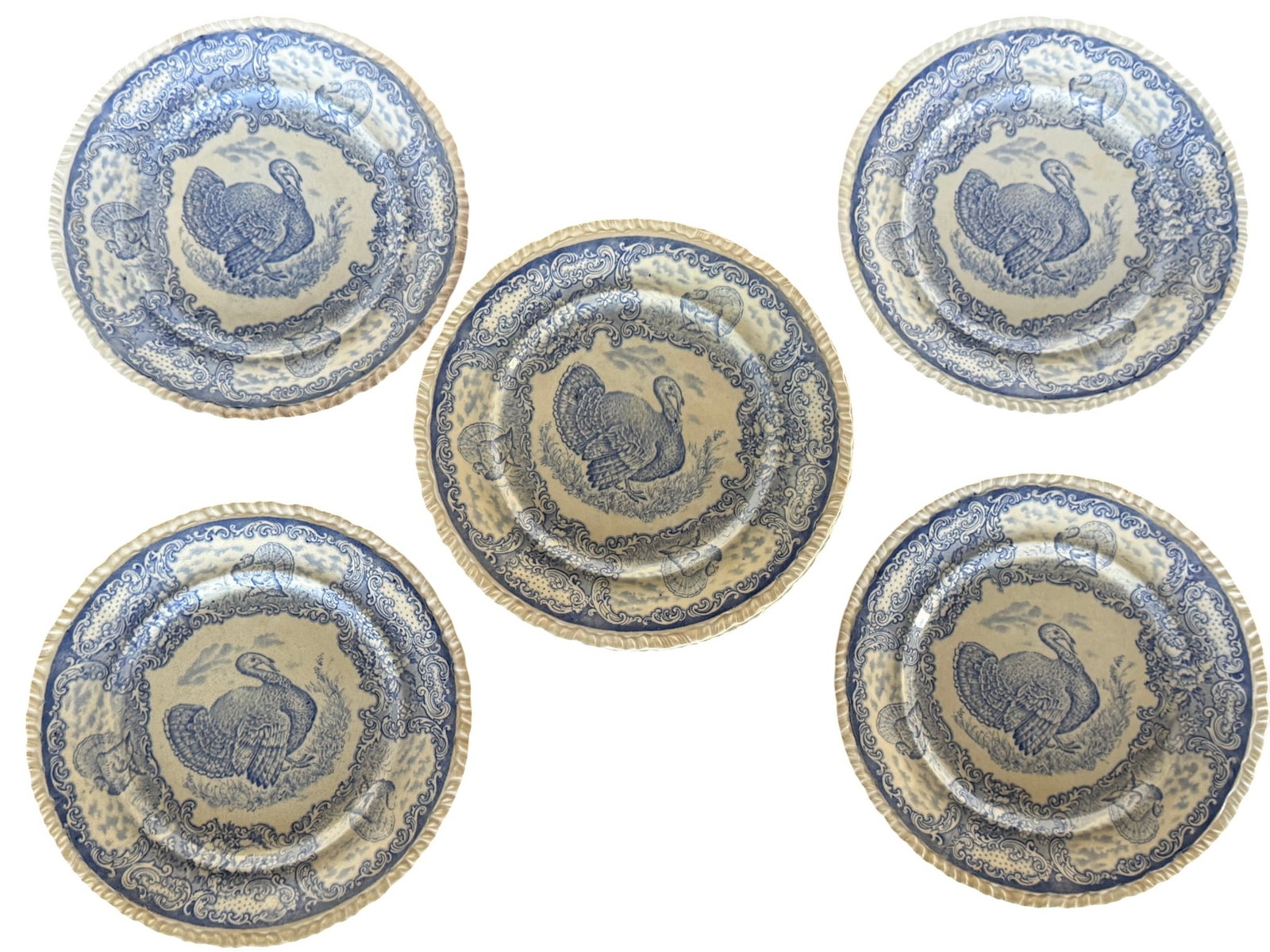 Set of Twelve Staffordshire Blue & White Transferware Turkey Plates: This lot comprises a set of twelve vintage Staffordshire blue and white transferware plates, each featuring a central motif of a turkey in a pastoral setting. The plates exhibit classic English