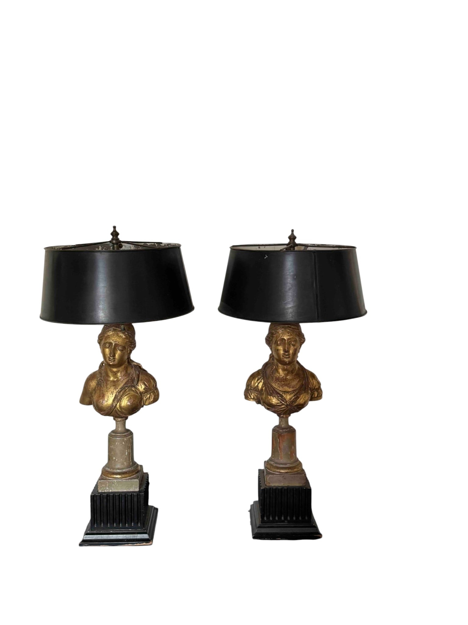 Pair of Neoclassical Giltwood Bust Lamps: A sophisticated pair of Neoclassical style table lamps, featuring giltwood busts surmounting fluted columns, resting on stepped black bases. The busts depict classical figures, rendered with intricate