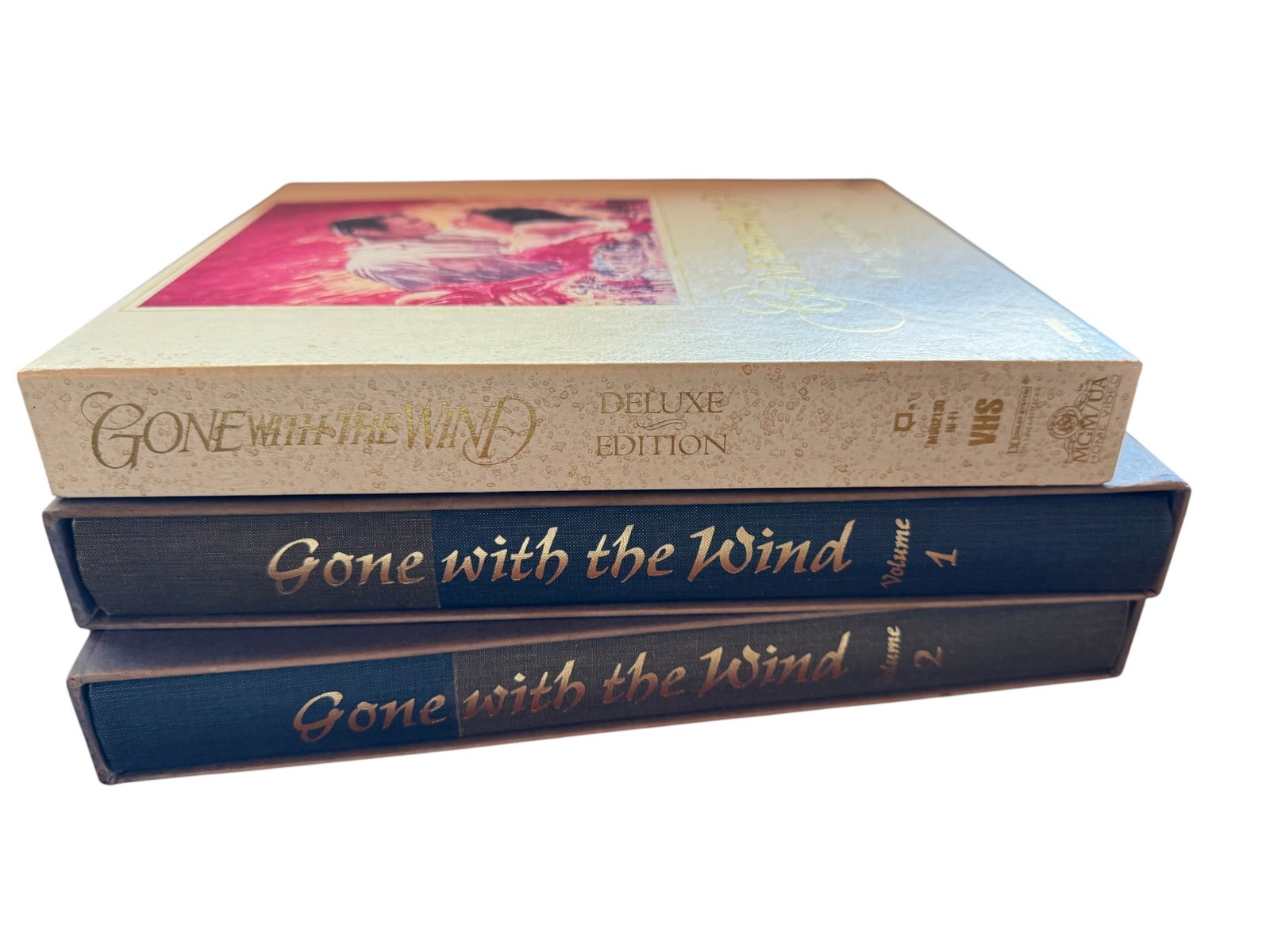 Gone With the Wind Set of Books & Deluxe Edition VHS Set: This lot features a "Gone With the Wind Deluxe Edition" VHS set, alongside a collectors edition set of two Gone with the Wind books. The set includes two VHS tapes, presented in a decorative slipcase.