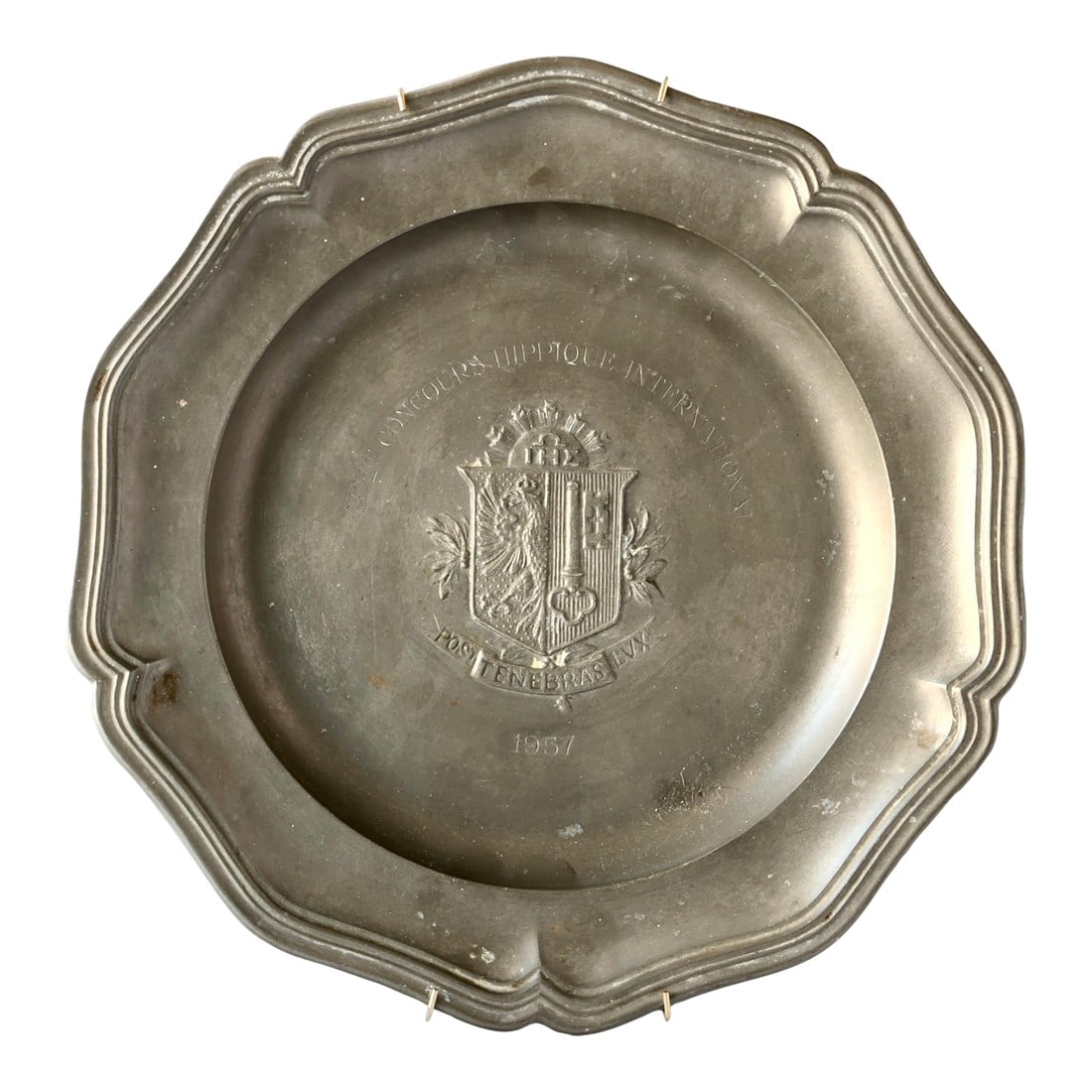 1957 French Equestrian Show Trophy Plate: A scalloped pewter plate awarded at the 1957 Concours Hippique International (International Horse Show). Features a French coat of arms and motto "Post Tenebras Lux" ("After Darkness, Light"). A