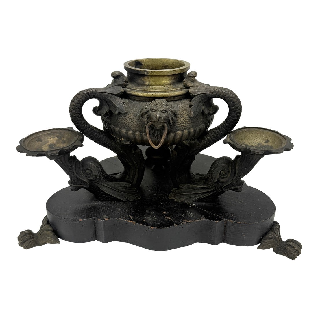 French Empire Bronze Inkwell After the Roman Oil Lamps, C. 1815–25: A richly detailed French Empire bronze and brass inkwell conceived in the archeological revival manner, after the form of ancient Roman oil lamps. The central reservoir, cast with a hammered surface a