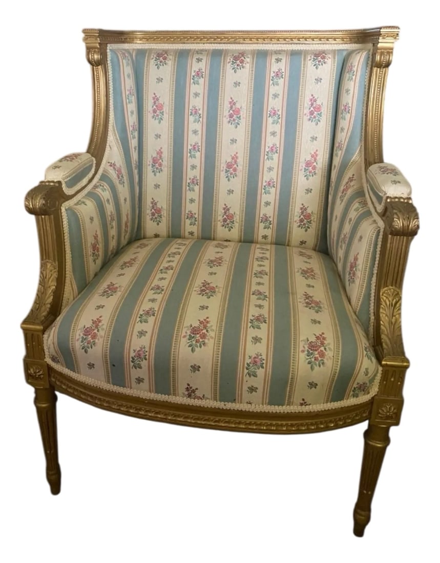 Louis XVI 19th C Gilded Bergere Chair: Gilded Neoclassical carved wood Louis XVI Bergere chair. Fine carved details on this chair made in France. Vintage blue and cream striped chair with pink floral details. This chair was once in the pre