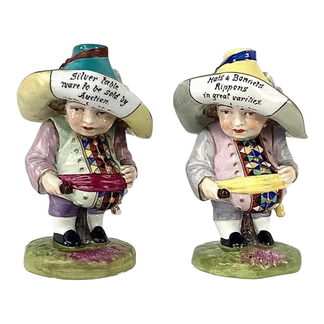 19th Century Derby Mansion House Dwarf Figurines, Set of 2: Wonderful pair of Derby Porcelain "Mansion House" dwarfs. Both figures are modeled wearing large hat advertisements, most likely as they stood outside Mansion House in London. Both are dressed in rich