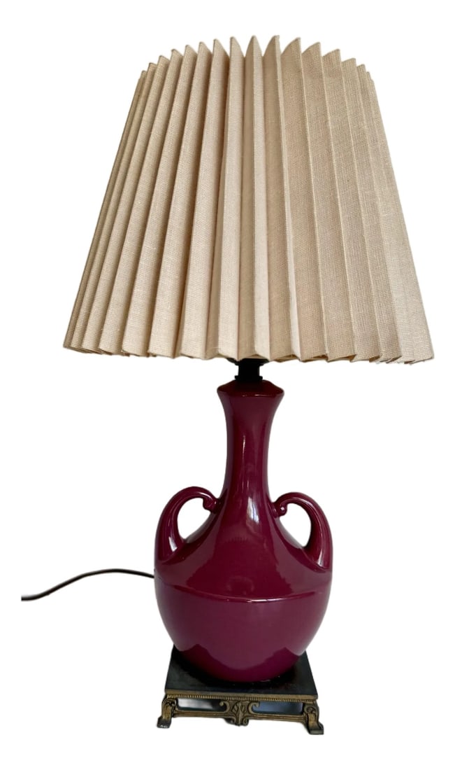 Vintage Burgundy Glazed Ceramic Amphora Double Handle Table Lamp With Pleated Shade: Here is a beautiful, vintage ceramic table lamp, likely dating to the 1960s, finished in a rich burgundy glaze that gives it a warm, inviting presence. The form is inspired by a classic amphora