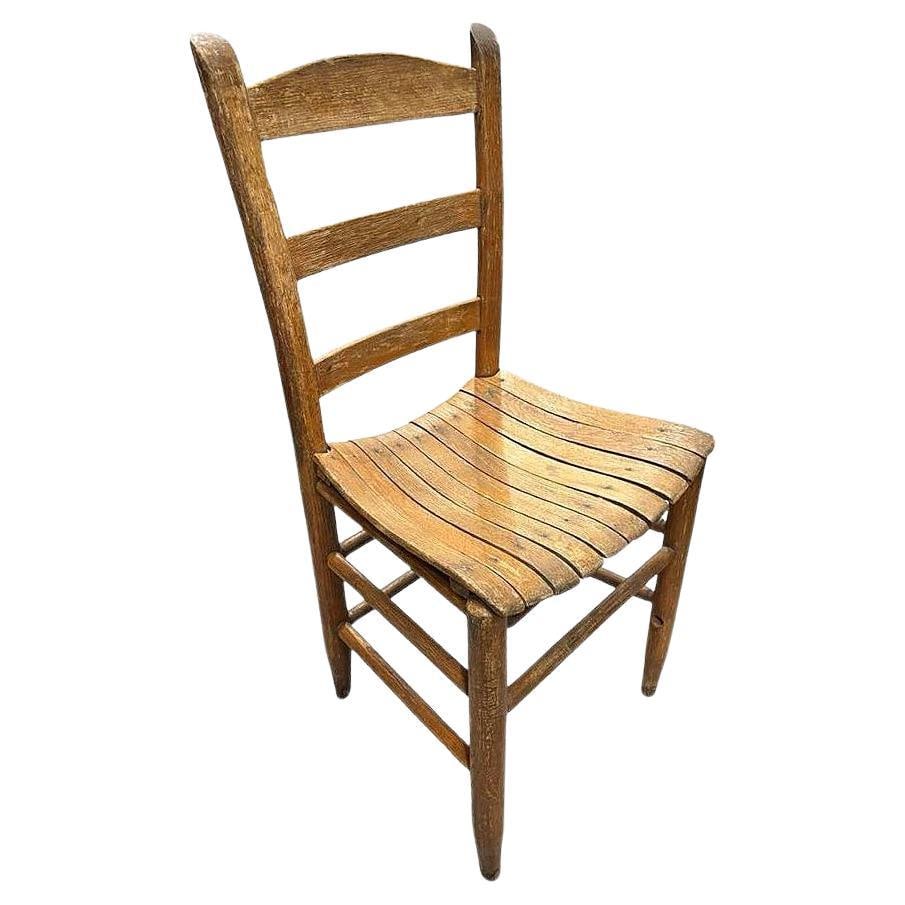 Antique Weathered Ladder Back Slat Seat Wooden Side Chair: Title: Antique Weathered Ladder Back Slat Seat Wooden Side Chair Description: This Antique ladder back, slat seat wooden side chair with its weathered, timeworn character. The chair features a classic