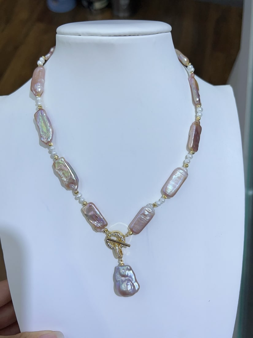 Natural Baroque Pearl Necklace: This natural Baroque pearl necklace embodies an extravagant and unique style, making it a fashion statement. The pearls, in their natural hue, measure approximately 9-10mm in width and 21-22mm in leng