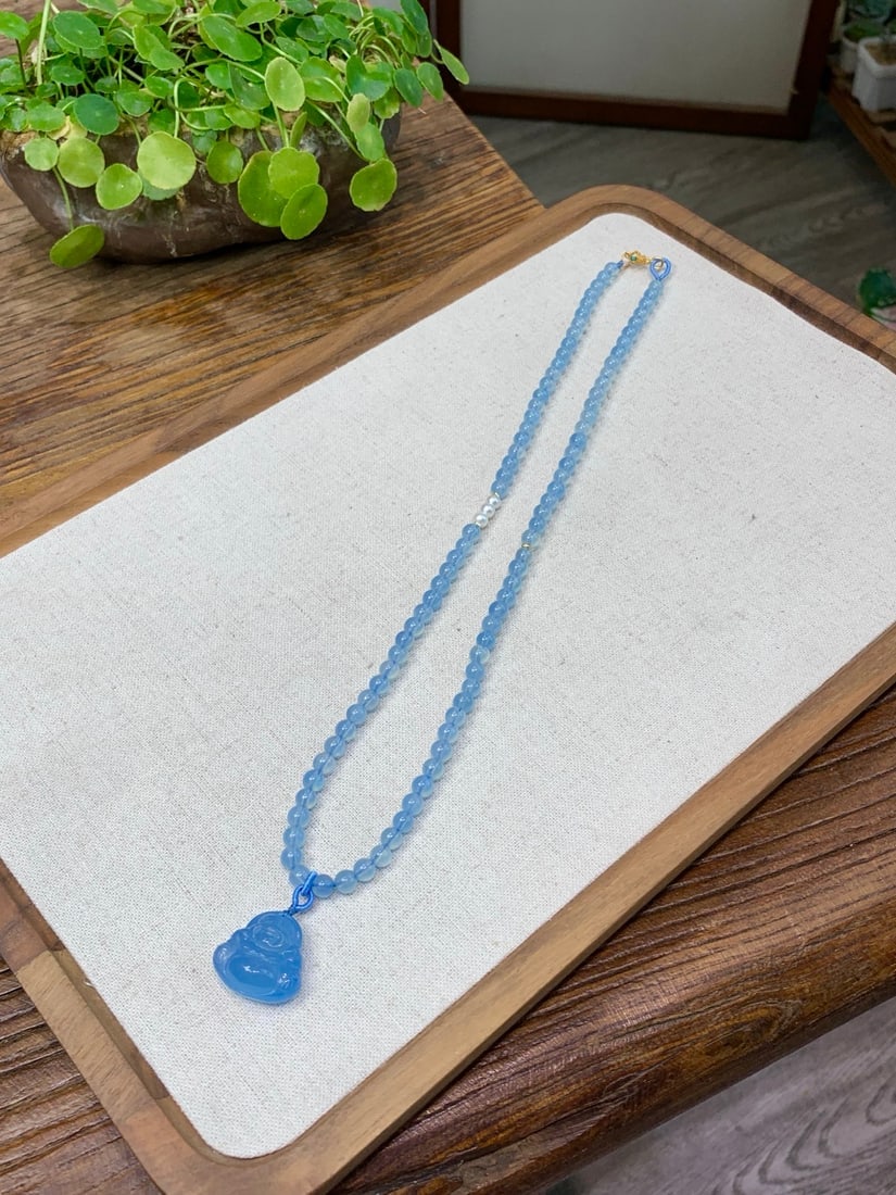 Aquamarine Carved Pendant: This pendant features an original design with natural aquamarine, showcasing rich golden and cool white hues. The exquisite carving highlights a nearly flawless texture. Its perfectly round design is 