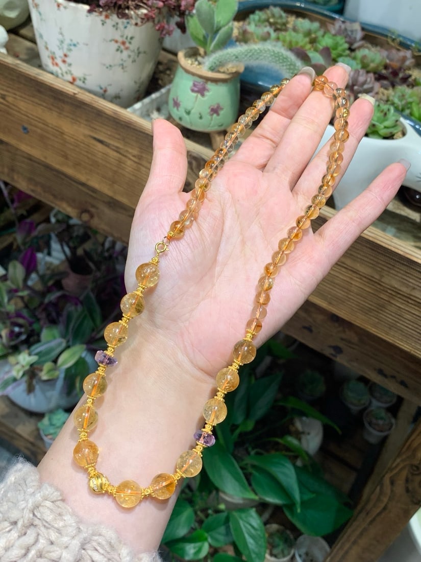 Citrine Necklace: This necklace features an original design with natural citrine, showcasing a warm hue and pristine crystal. Known for its rich golden color, the citrine is paired with faceted amethyst and crafted wit