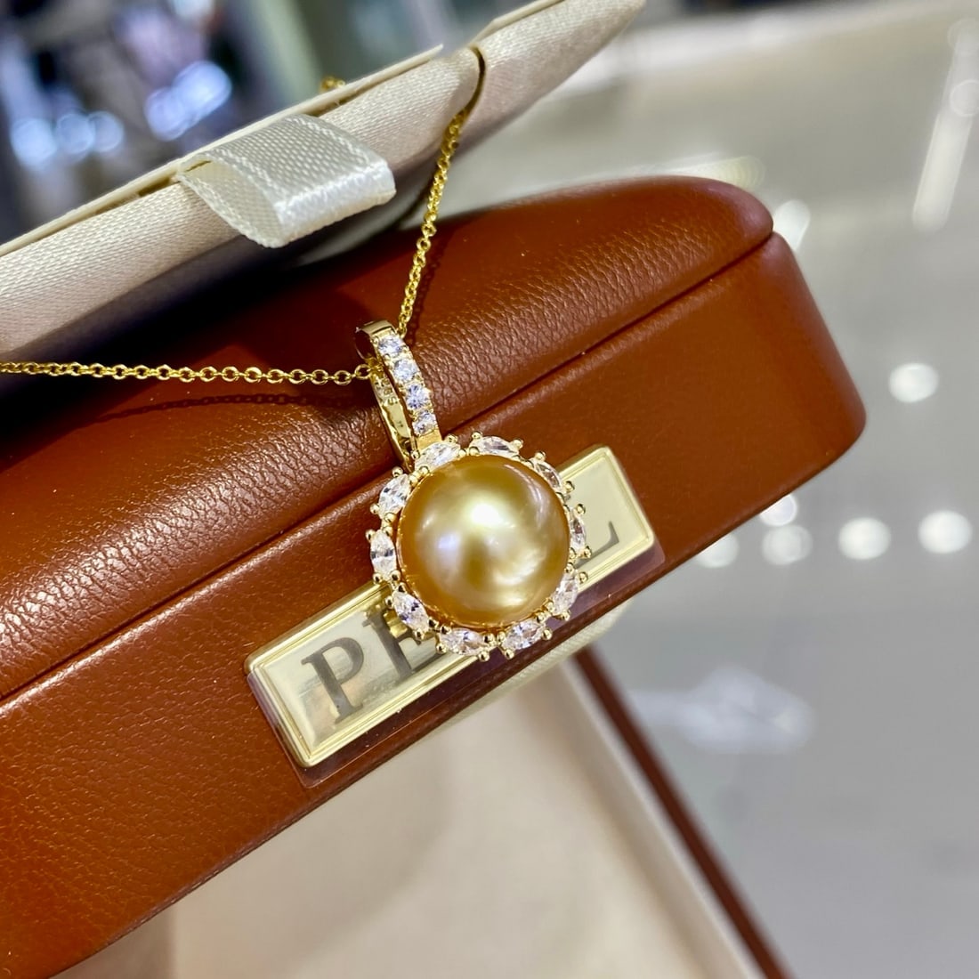 Natural Golden Pearl Pendant: This necklace features natural South Sea pearls with a diameter of 11-12MM, exhibiting a perfect round shape and minimal blemishes, radiating a rich golden hue. Complemented by a gold-plated silver su