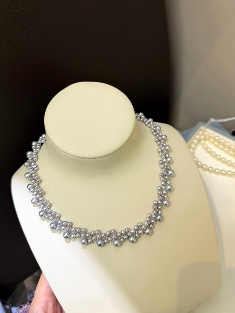 Natural Gray-Blue Pearl Necklace: This necklace features pearls in a unique gray-blue hue, with a multi-layered woven design. The pearls vary in size, creating a rich, three-dimensional effect. Each layer cascades from the neck to the