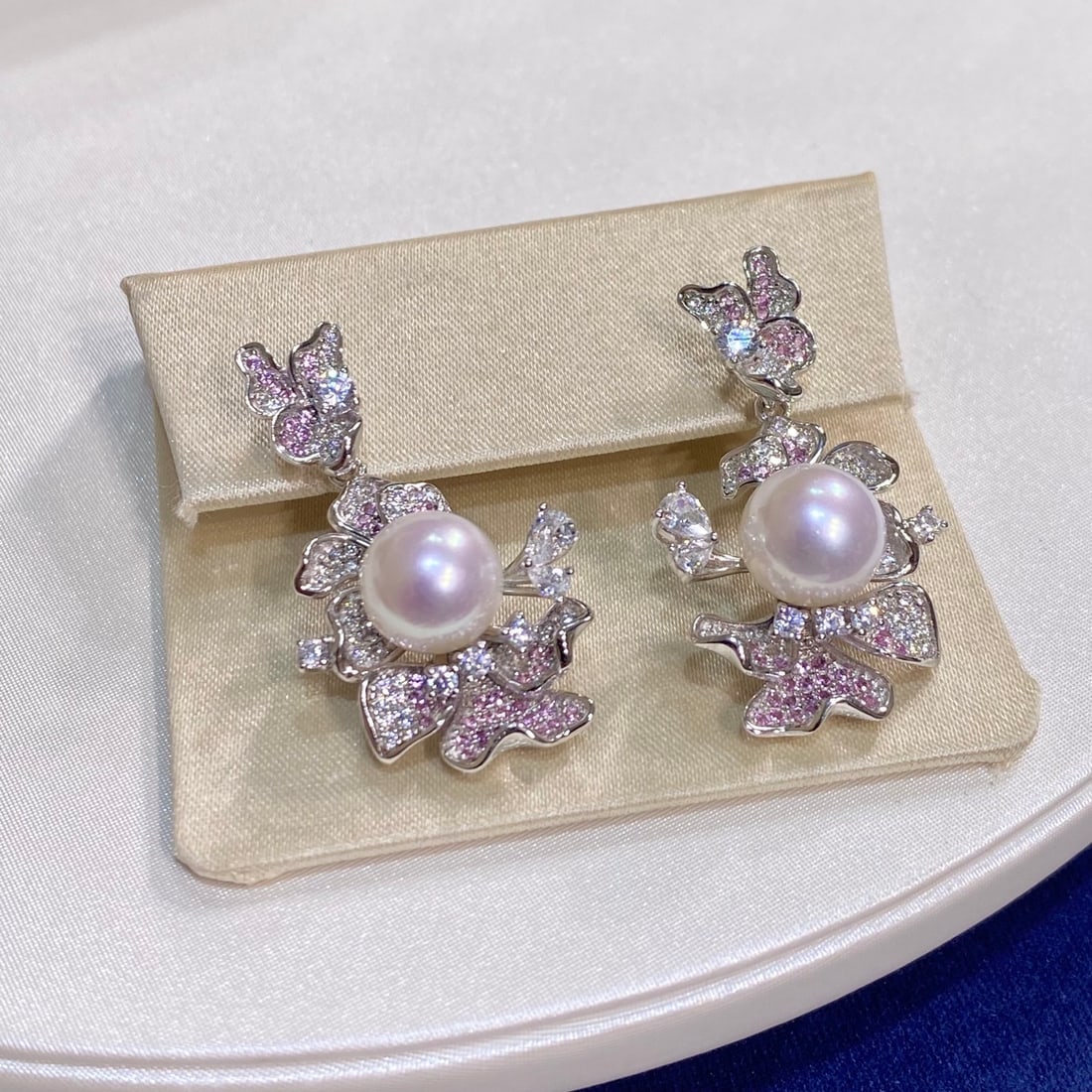 Silver Natural Freshwater Pearl Earrings: These earrings feature large diameter 9-10mm natural freshwater pearls with a strong pink luster. The pearls are round with minimal blemishes, showcasing high quality. Crafted with intricate silver