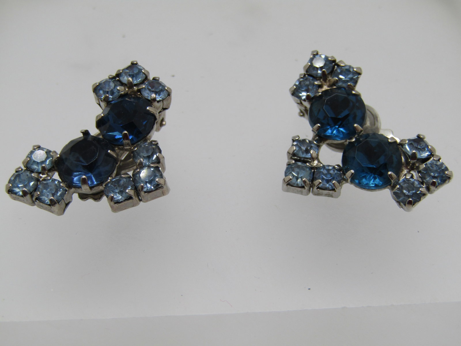 Vintage Blue Rhinestone Clip Earrings, 1940's-1950's.: Vintage Blue Rhinestone Clip Earrings, 1940's-1950's. Dark blue 8mm round rhinestones with light blue 3mm rhinestones set in groups of threes in three areas on each earring. The earrings are appx. 1.2