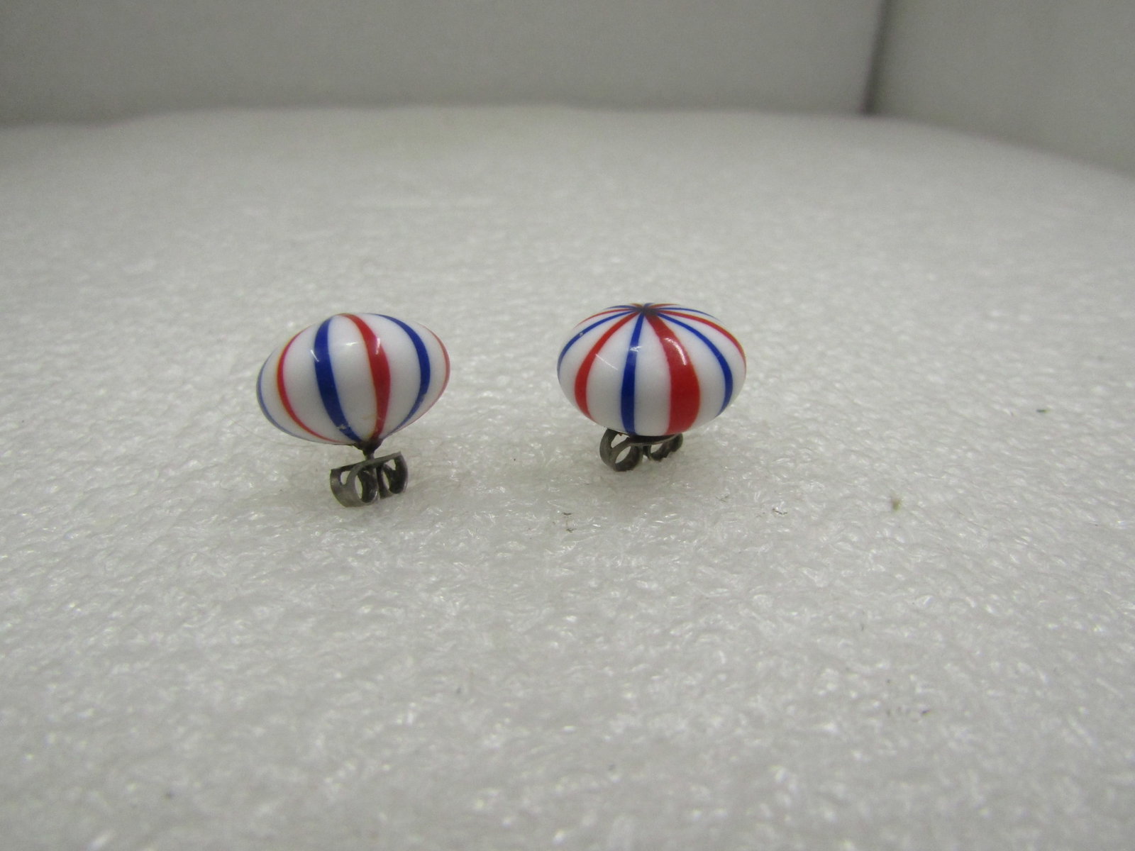 Vintage Red/White/Blue Striped Glass Earrings, Pierced: Vintage Red/White/Blue Striped Glass Earrings, Pierced. They are appx. 14.5mm wide and 9.5mm tall. White glass with red and blue stripes. Age is estimated 1950's-1960's. They have silver tone or