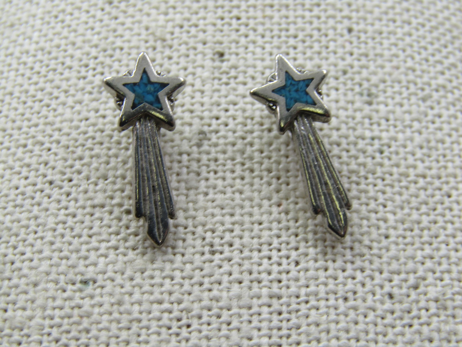 Turquoise Chip Shooting Star Earrings, 1983 Signed, Pierced: Turquoise Chip Shooting Star Earrings, 1983 Signed, Pierced. The star is appx. 8mm across with the center having inlaid turquoise chips, with the tail, the measurement is appx. 18mm. They are marked