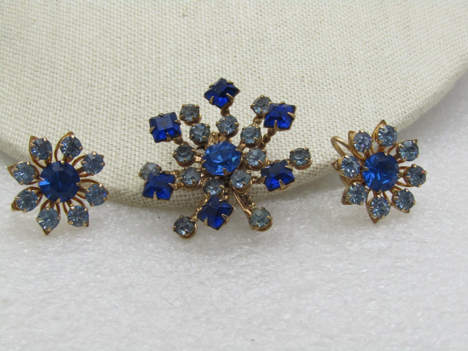 Vintage Rhinestone Brooch & Earrings Set, Screwback, 1950's-1960's: Vintage Rhinestone Brooch & Earrings Set, Screwback, 1950's-1960's - lshades of blue in light, medium, and dark, and a mis of round and square stones. Tiered design with gold tone se The brooch is 1.5