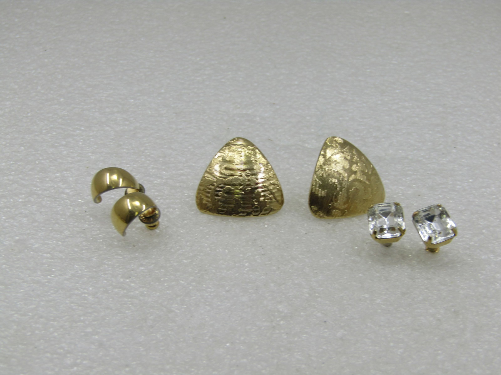 Vintage 3 Pair of Pierced Earrings, Gold Tone, 1980's-1990's: Vintage 3 Pair of Pierced Earrings, Gold Tone, 1980's-1990's. Very clean earrings - etched domed triangular studs that are appx. 7/8" down each side; 10mm by 8mm emerald cut rectangular clear rhinesto