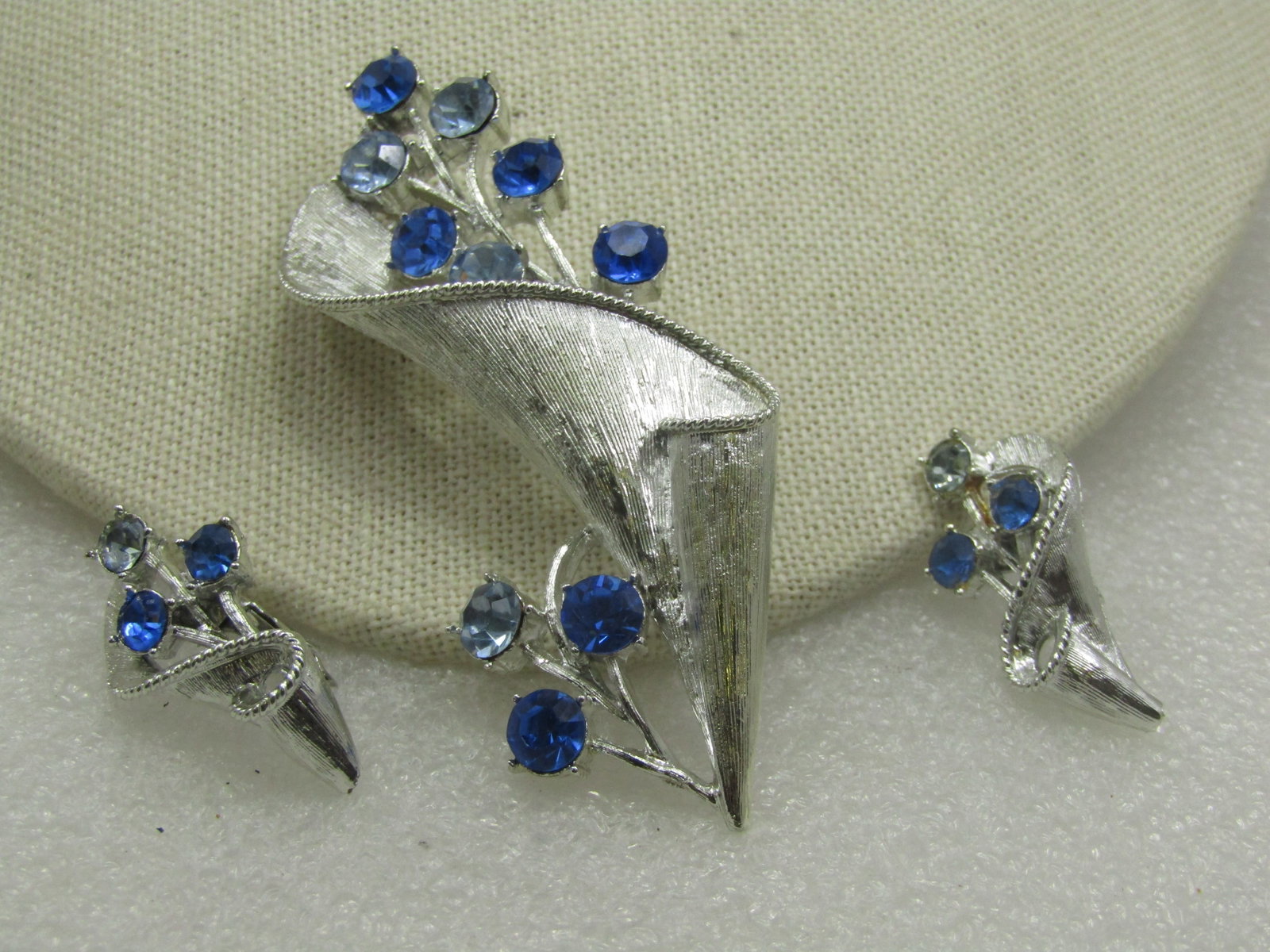 Vintage Coro Blue Rhinestone Modern Floral Brooch & Earrings , 1960's: Vintage Coro Blue Rhinestone Modern Floral Brooch & Earrings , 1960's. This has a textures wrapped design around a stem of light blue and dark blue rhinestone branch or blossoms to the side and coming