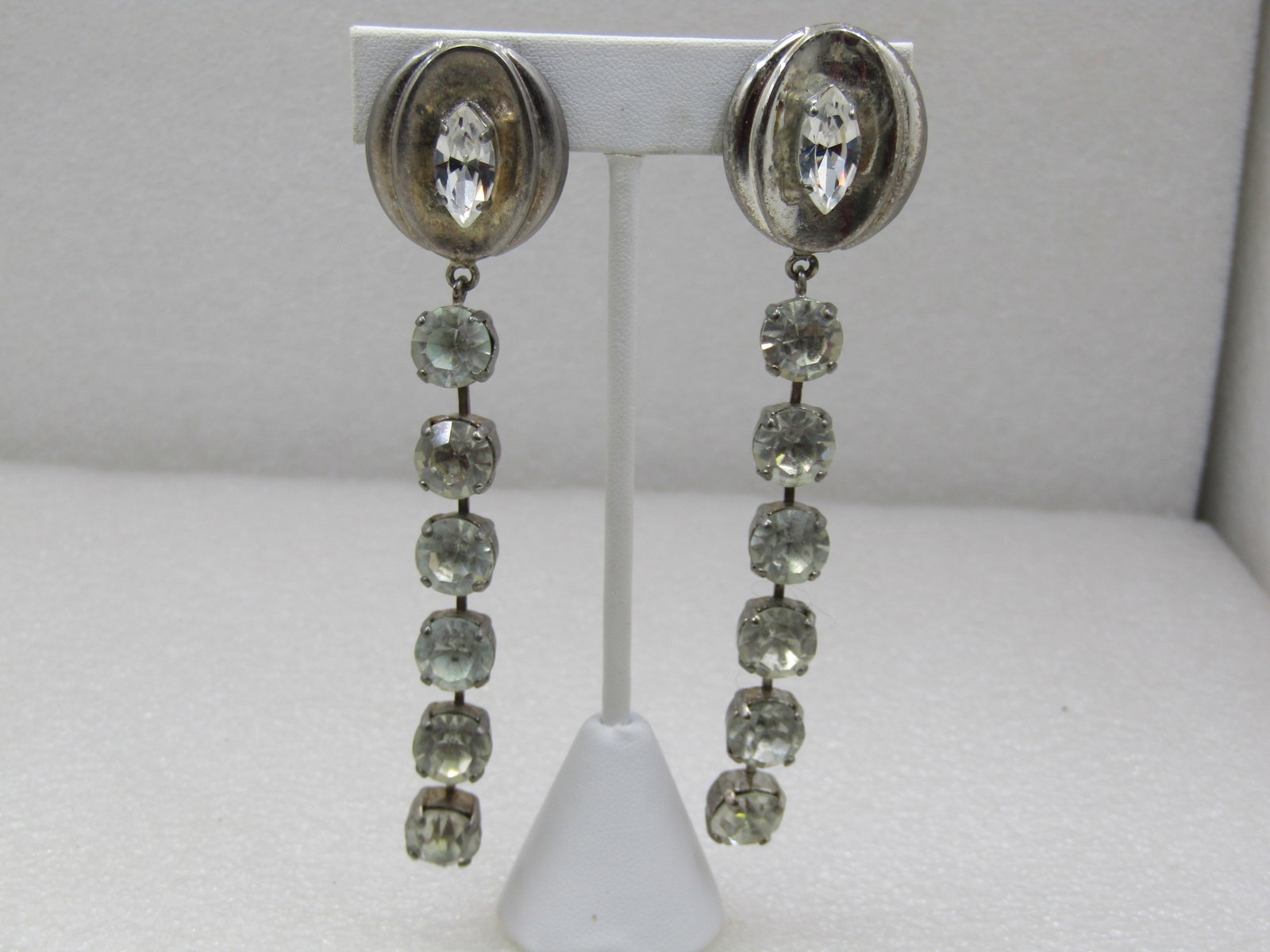 Vintage Art Deco Long Rhinestone Earrings, Clip, 1960's: Vintage Art Deco Long Rhinestone Earrings, Clip, 1960's. 4.25" long, runway statement earrings. six appx. 9mm round rhinestones in each earring in a trailing drop from a ridged oval silver tone 1" top