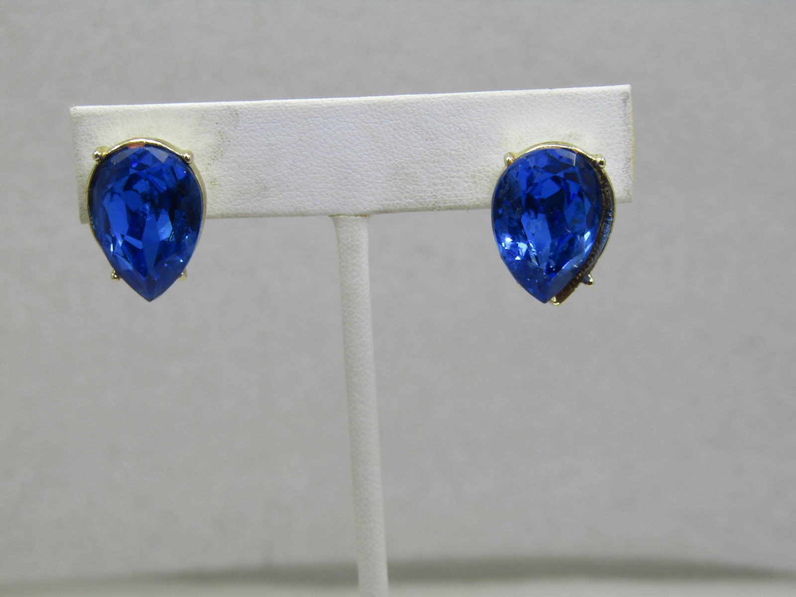 Vintage Blue Rhinestone Earrings, Hinged Clip. 1980's: Vintage Blue Rhinestone Earrings, Hinged Clip. 1980's. These are pear-shaped sapphire blue glass/crystal stones that are appx. 18mm by 12mm. The setting is closed back with prongs and I believe the st