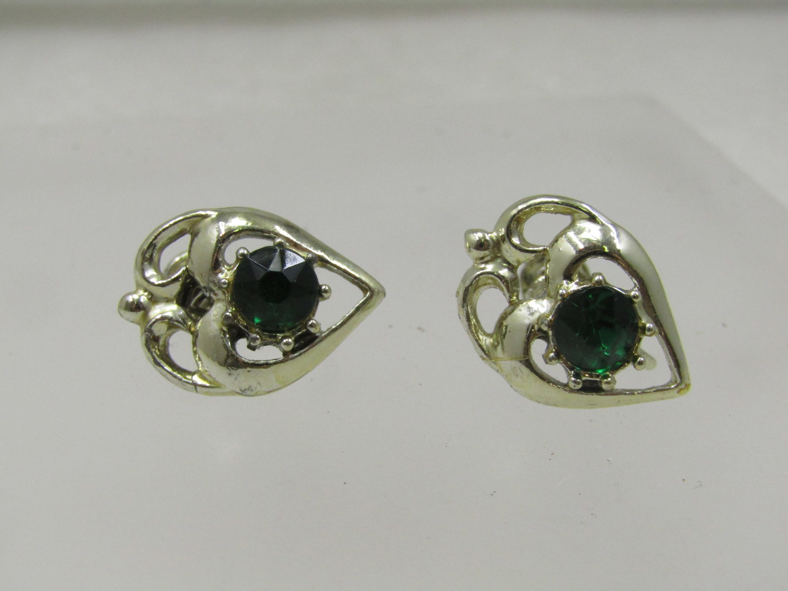 Vintage Green Rhinestone Leaf Earrings, Screwback, 1940's-1960's: Vintage Green Rhinestone Leaf Earrings, Screwback, 1940's-1960's. They are appx. 3/4" long and 5/8" wide in the shape of a leaf with an emerald green colored 6mm round stone. Gold tone. Very good