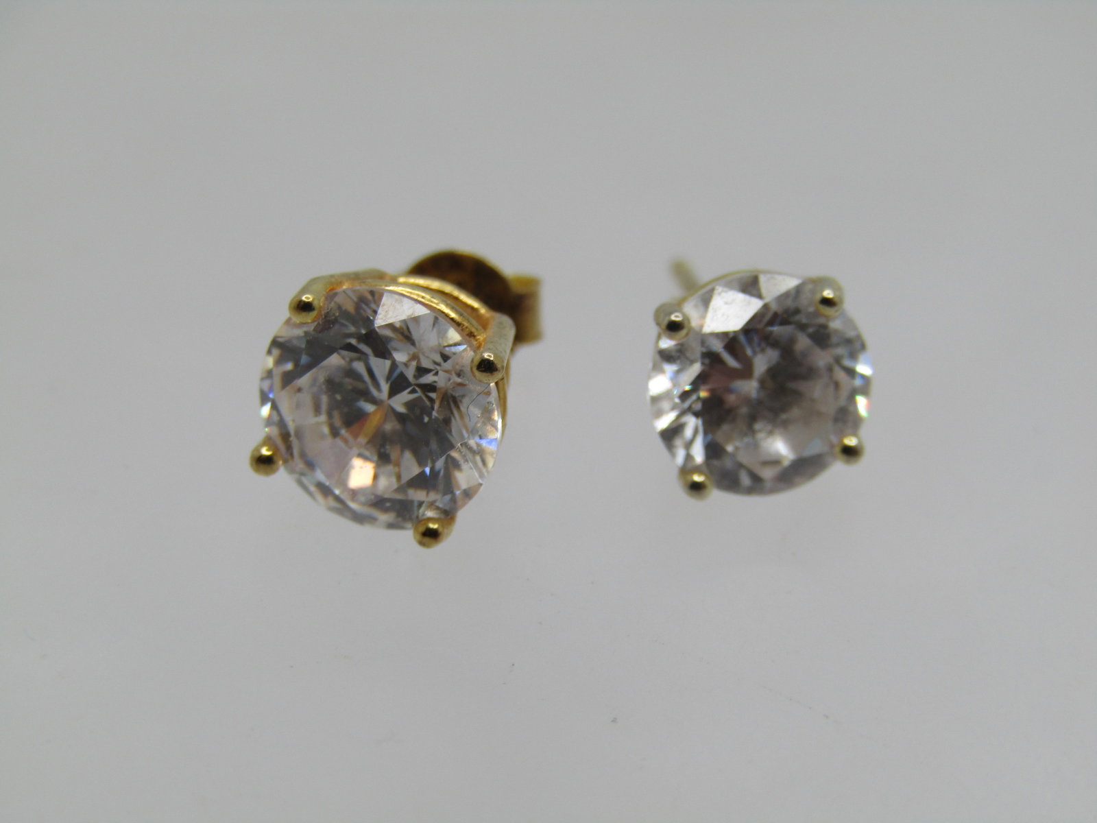 Vintage Two Sterling CZ Stud Earrings, 7mm and 8mm: Vintage Two Sterling CZ Stud Earrings, 7mm and 8mm. Gold over sterling, marked .925 and test as sterling with a combined weight of 2.31 gr. One clutch is not sterling and not calculated in the weight.