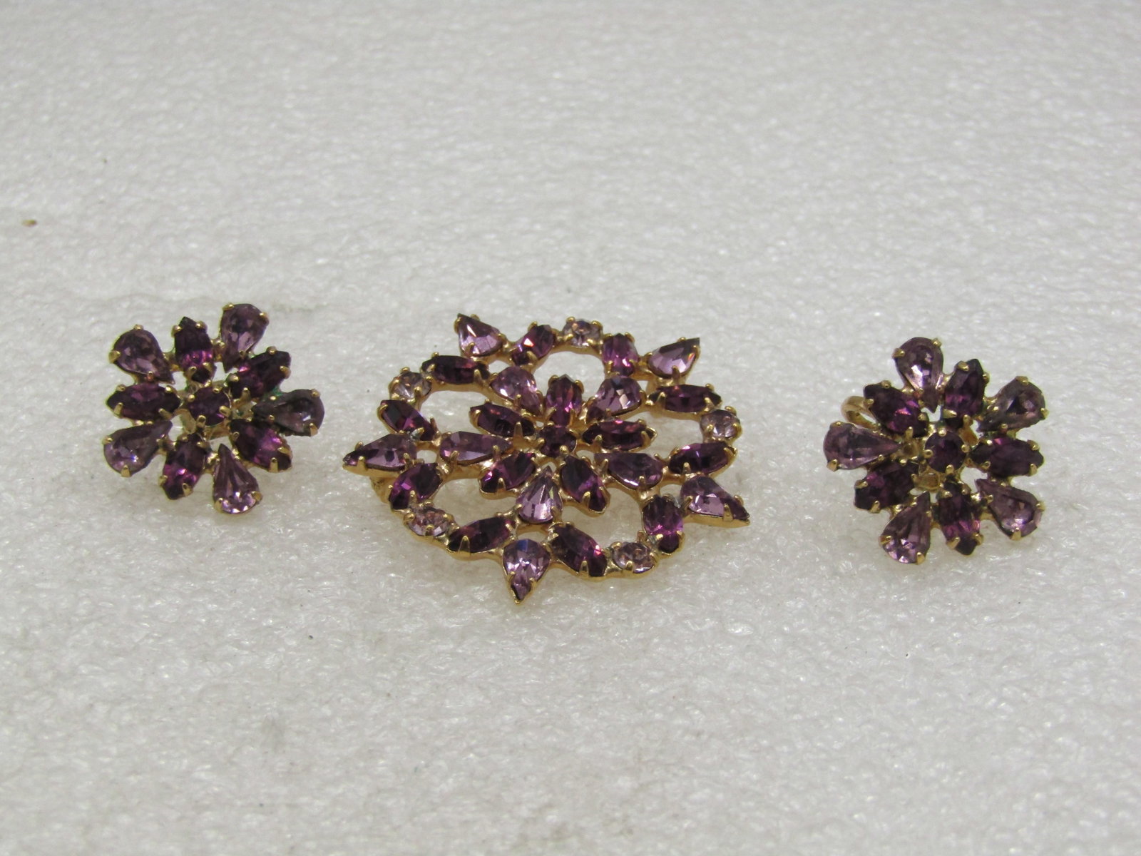 Lavender & Purple Rhinestone Brooch & Earrings,: Lavender & Purple Rhinestone Brooch & Earrings, 1960's-1980's, gold tone, snowflake type design with open areas around the stones, pear-shaped and round. It is marked 1958 Pat for the type of clip