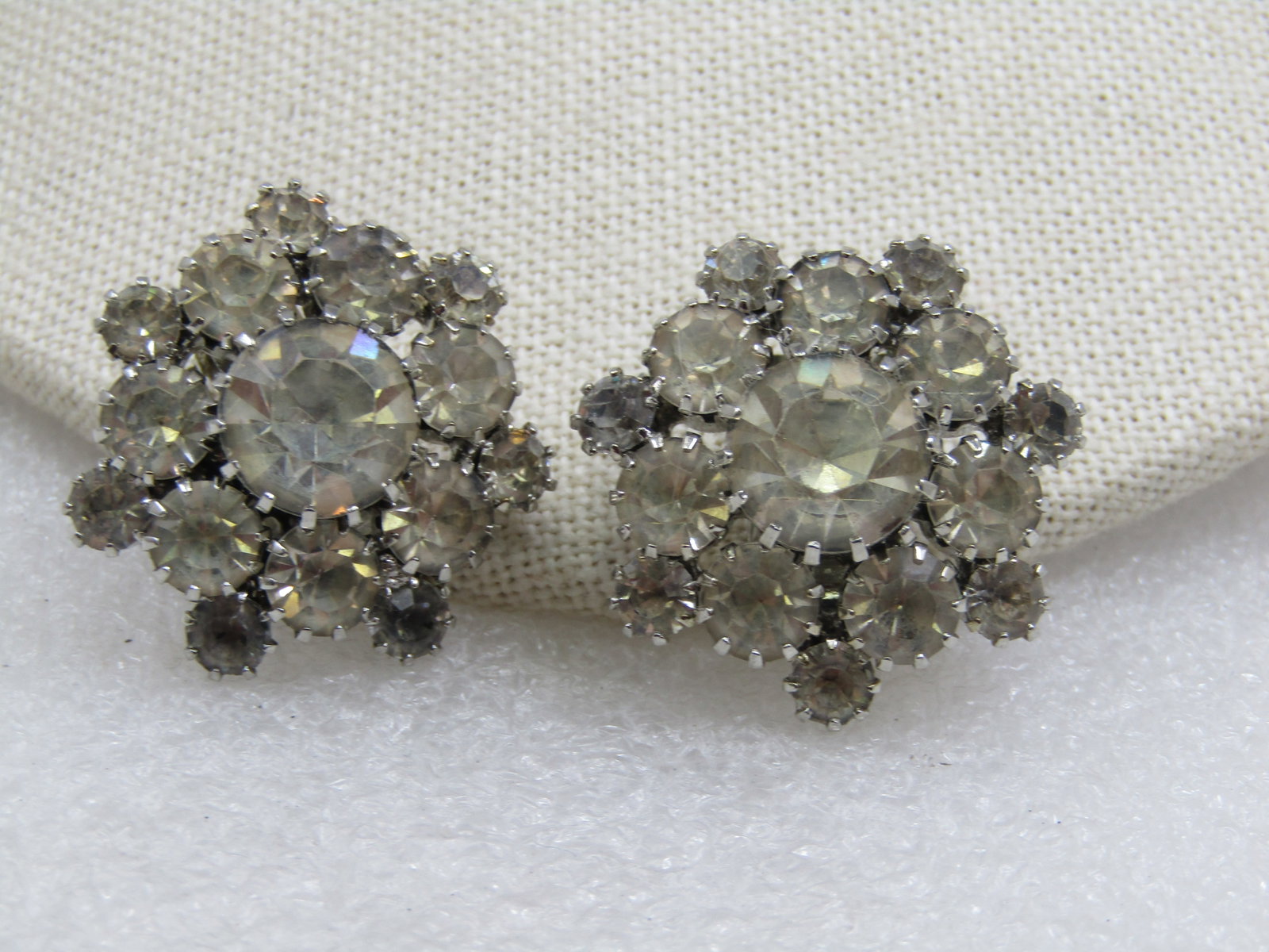 Vintage Rhinestone Blossom Clip Earrings, 1.25": Vintage Rhinestone Blossom Clip Earrings, 1.25". Clear rhinestones, round that are appx. 4mm, 5.5mm and 10mm with the largest set raised in the center. Silver tone setting with a multi-prong setting o
