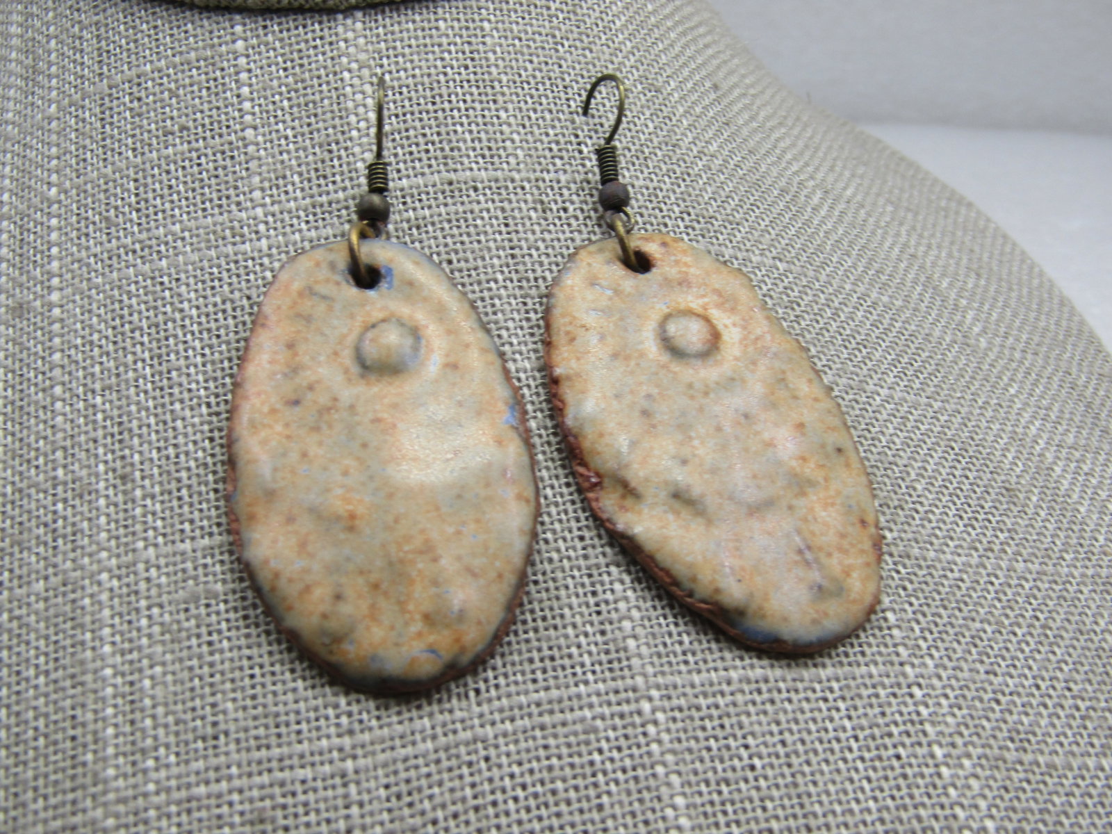 Vintage Hand Made Glazed Clay Earrings 2-3/8": Vintage Hand Made Glazed Clay Earrings 2-3/8" from the curve in the hook post. They are a rustic oval shape with a sunburst design, primitive style and glased over with a milky cream color and appx.