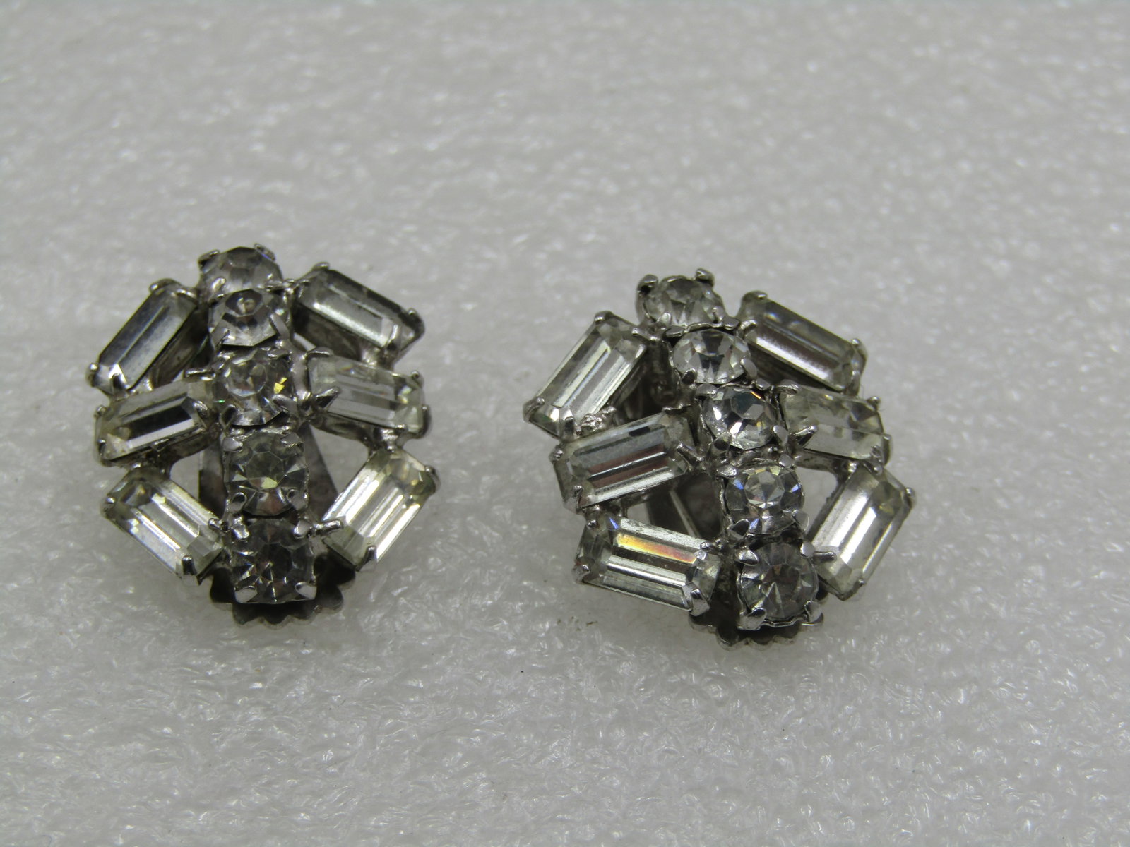 Vintage Rhinestone Art Deco Themed Clip Earrings, 1940's-1950's: Vintage Rhinestione Art Deco Themed Clip Earrings, 1940's-1950's. aPPX. 1" across. Silver tone setting with six large baguettes in each earrings and 5 round stones in each. The baguettes are appx. 8mm