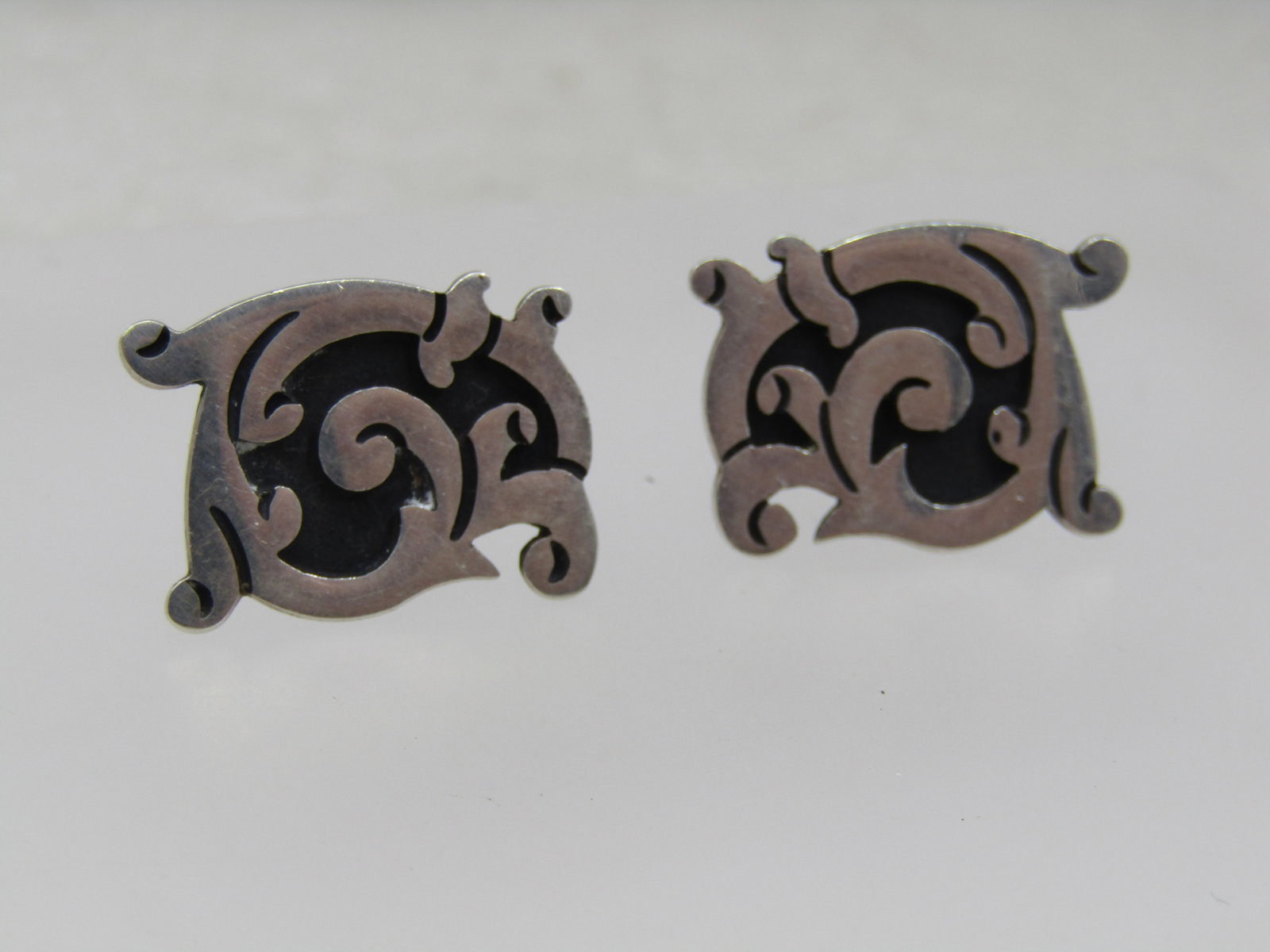 Vintage Sterling Taxco Scrolled Earrings, Screwback, 1960's-1970's: Vintage Sterling Taxco Scrolled Earrings, Screwback, 1960's-1970's. These have a blackened recessed area with raises scrolled design . They are 1" and 3/4". The one is signed where you can partially s