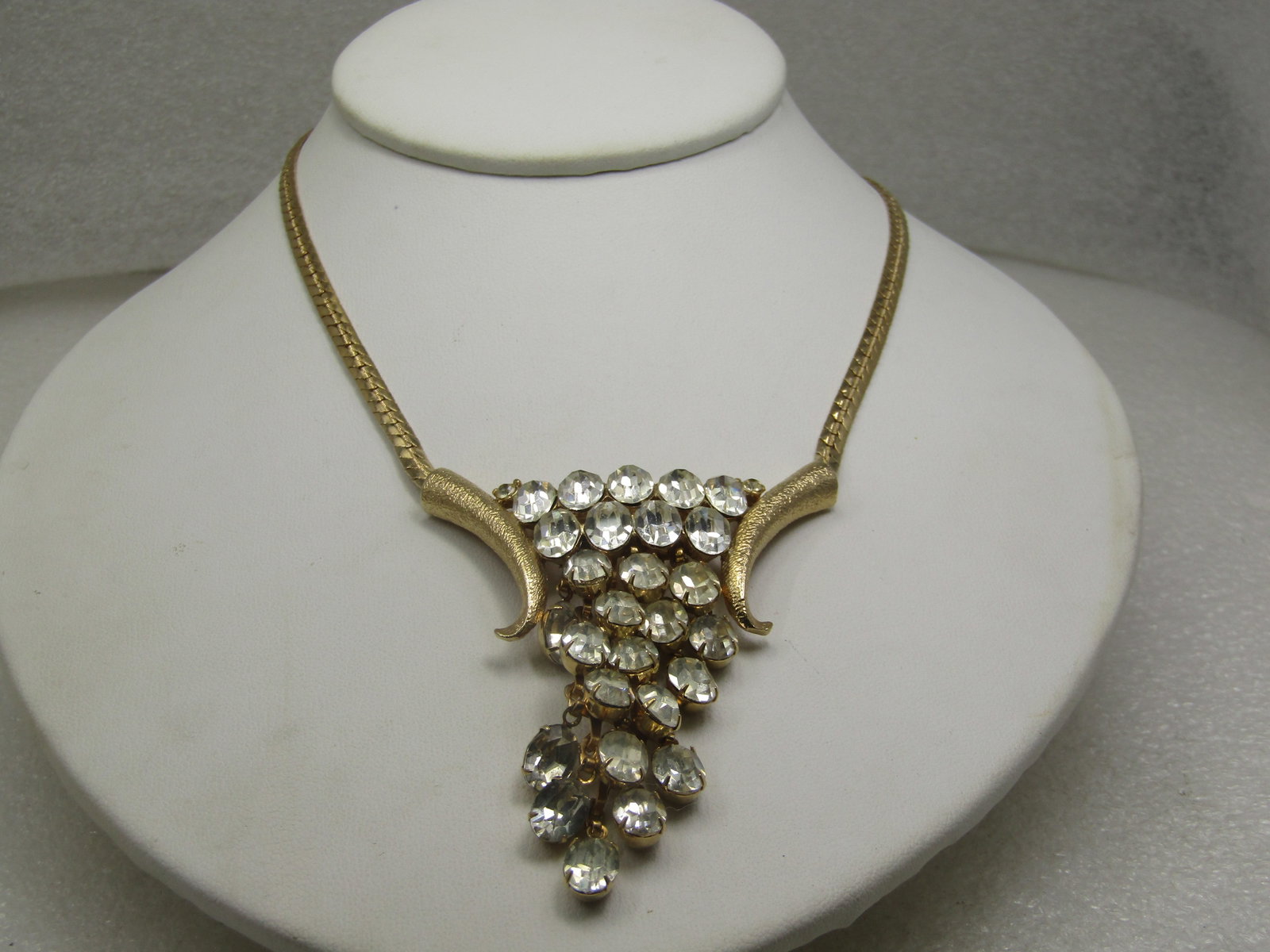 Vintage Clear Cascading Rhinestone Necklace Earrings Sett, 15": Vintage Clear Cascading Rhinestone Necklace Earrings Sett, 15". the clear oval rhinestones cascading down appx. 2.5" the drop has curved gold tone textured accents on each of the cascading rhienstones