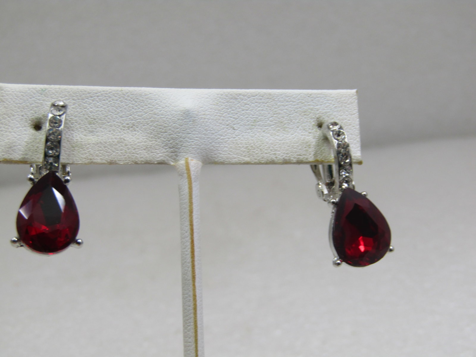 Vintage Red & Clear Rhinestone Clip Earrings, 1-1/8": Vintage Red & Clear Rhinestone Clip Earrings, 1-1/8" and 1/2" wide. These have a curved hoop pave clear rhinestone top and a drop of a red pear-shaped rhinestone that is appx. 13mm by 10mm. Silver ton