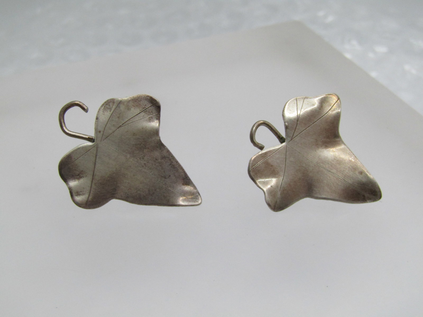 Vintage Sterling Leaf Earrings, Screwback, 1940's: Vintage Sterling Leaf Earrings, Screwback, 1940's. They have subtle designs in the leaves with a curved stem - they are not completing flat but have higher/lower areas for detail. They have a pointed 