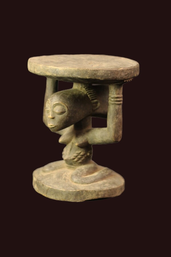 Stool – Wood – Luba – DR Congo: Powerfull Luba stool from DR Congo. Wondeful aged patina and great stylistic and detailed hairdo. In many cultures throughout the southeastern region of the Democratic Republic of Congo the seats of