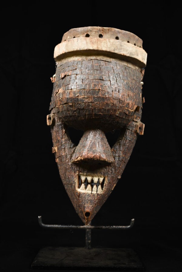 Initiation mask – Wood, Copper – Salampasu – Congo: Light wooden mask from the Salampasu tribe of DR Congo. Stunning and frightning Salampasu mask. The wooden mask is covered with thin copper plates and red seeds. SALAMPASU masks are famous and are cha