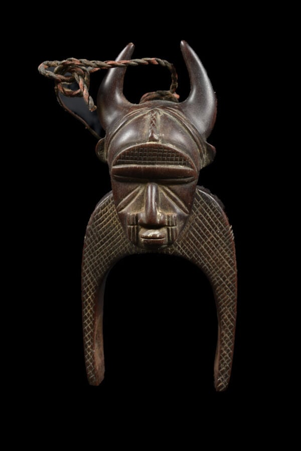 Pulley – Djimini – Wood – Ivory Coast: Djimini, Ivory Coast: a typical heddle pulley with ancestor head. A heddle pulley, in which a reel runs over an axle below. With a thread over this reel, the weaver can separate the warp threads of